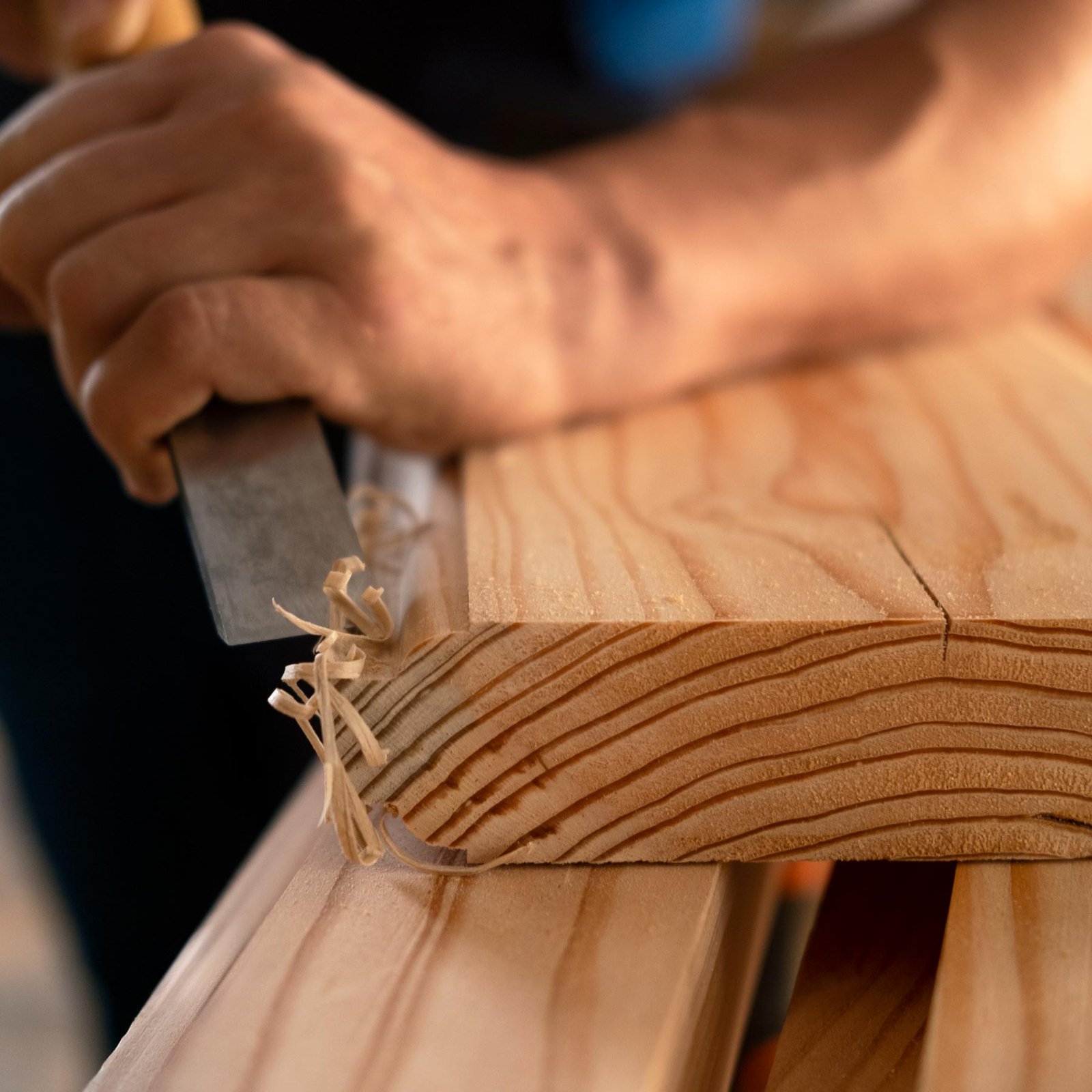 Homme travaillant le bois dans un atelier de menuiserie.